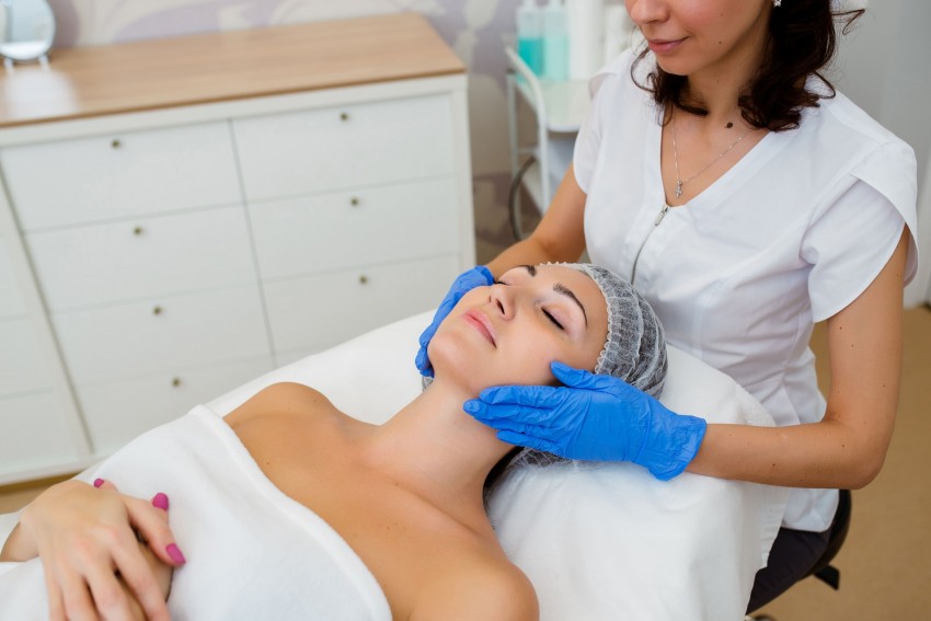 esteticista massageando rosto de paciente